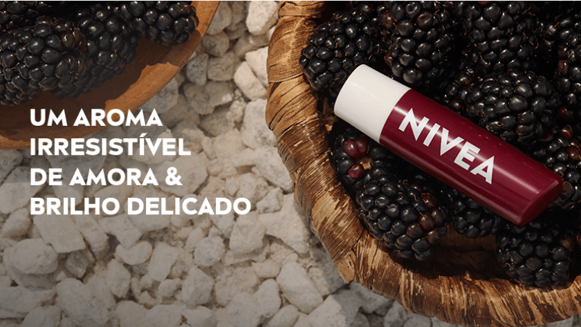 chao com pedras lisas em tons claros e dois cestos de palha com amoras frescas, grandes e com aspecto suculento, e sobre o cesta da direita está e a embalagem do Shine de Amora sobre elas.
