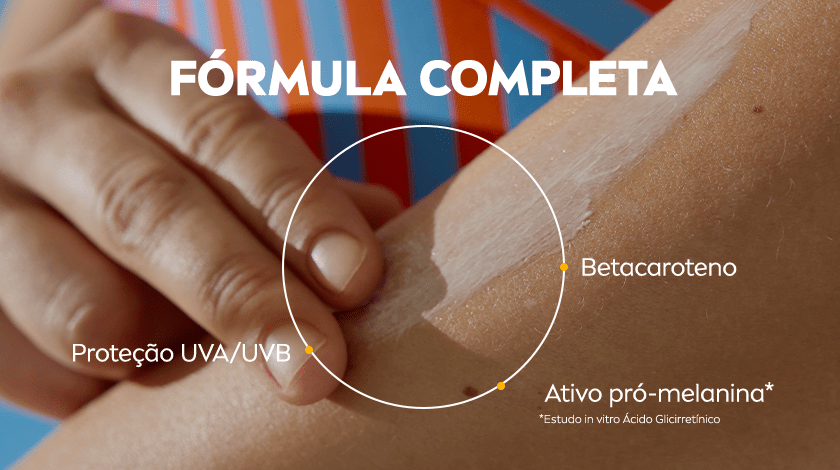 Close na aplicação do protetor solar em um braço. Um dedo espalha o produto sobre a pele. Círculo com setas destaca os ingredientes da fórmula.