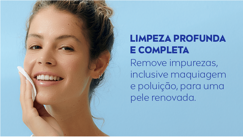 Mulher aplicando o produto no rosto, enquanto sorri. O fundo é azul claro.