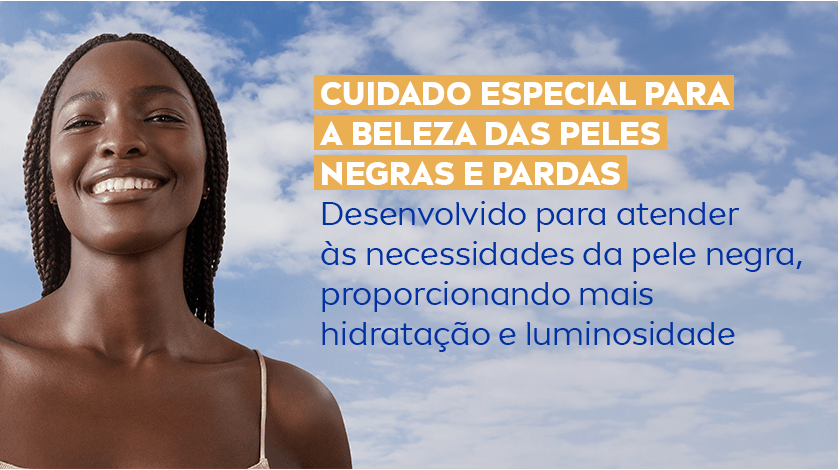 Mulher negra sorrindo com a pele hidratada. O fundo é um céu azul com nuvens.