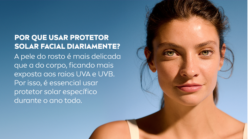Uma mulher olha para frente, sua expressão é neutra. O fundo é um céu azul em degradê suave.