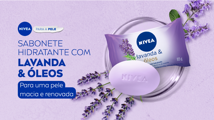 Fundo lilás. À esquerda, aparecem os textos promocionais da NIVEA em azul escuro e branco. À direita, estão os produtos em destaque: uma embalagem de sabonete com detalhes roxo, acompanhada de uma unidade do sabonete em barra de cor lilás com a marca “NIVEA” gravada no centro. Flores de lavanda decoram a cena, o produto está dentro de um pequeno prato redondo de vidro.
