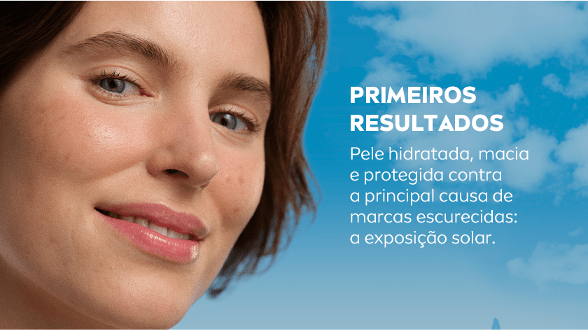 Close no rosto de mulher com pele hidratada e luminosa, com texto informativo sobre os primeiros resultados do uso: pele protegida da exposição solar, hidratada e macia.