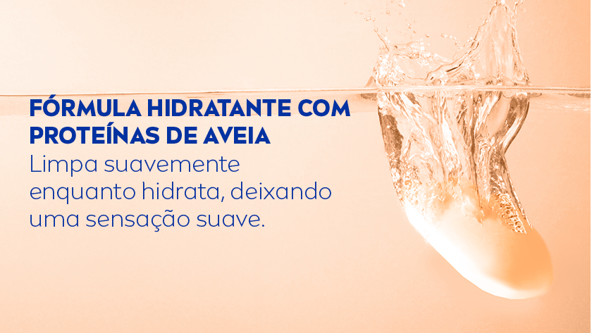 Fórmula hidratante com proteínas de aveia Limpa suavemente enquanto hidrata, deixando uma sensação suave. Fundo salmão. À direita, há uma barra de sabonete sendo mergulhada na água, criando respingos e movimento no líquido.