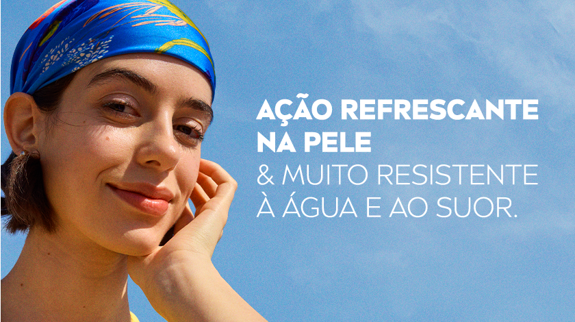 Mulher sorridente com bandana azul e cabelos soltos ao vento.