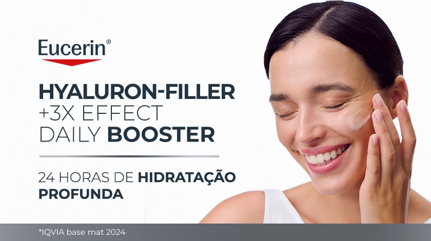 Imagem com fundo branco. Ao lado direito, uma mulher sorri de olhos fechados, enquanto aplica o produto suavemente no rosto.