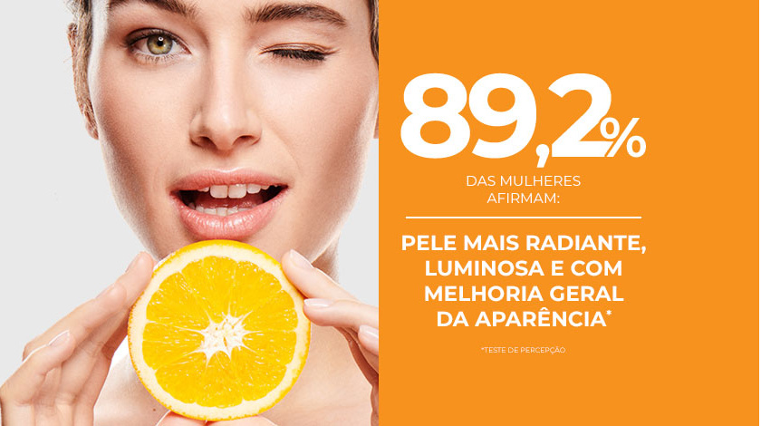 Uma mulher branca pisca enquanto segura uma fatia de laranja perto do rosto. Ao lado, em destaque sobre fundo laranja, o texto aparece.