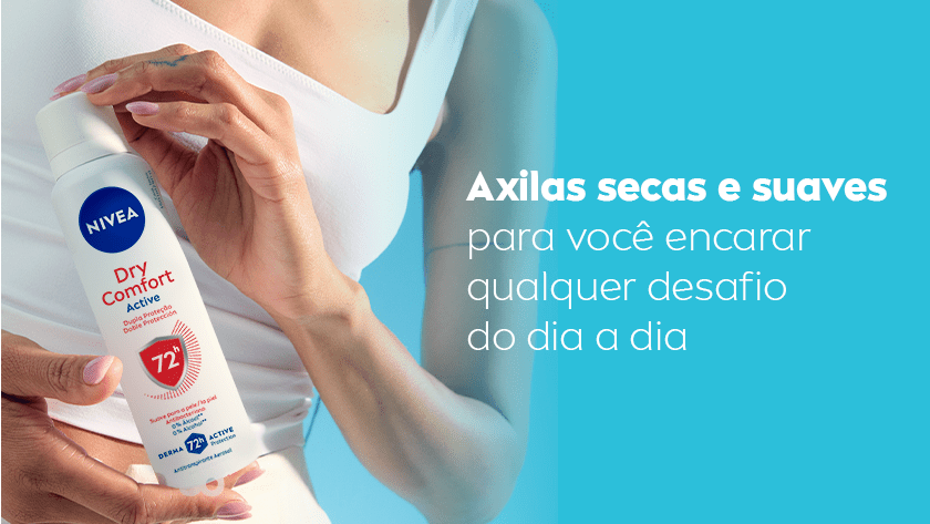 Close de uma mulher segurando o desodorante Aerossol NIVEA Dry Comfort Active. Ela usa uma regata branca e o fundo é azul.