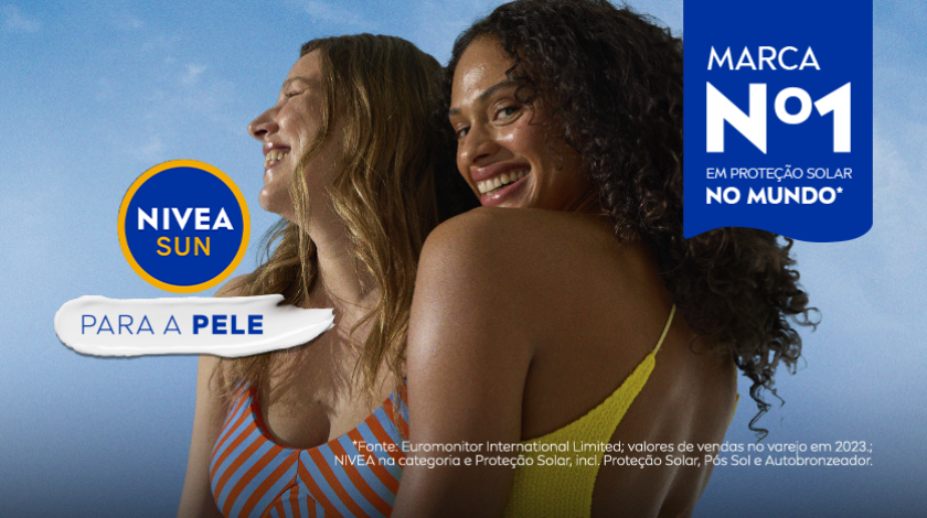 Duas mulheres sorrindo, uma de biquíni amarelo e outra de maiô listrado, com fundo azul.