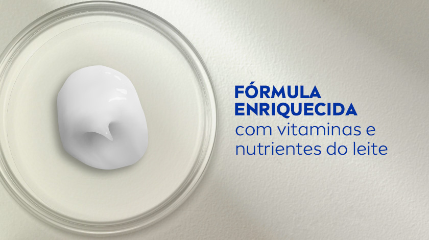 Fórmula enriquecida com vitaminas e nutrientes do leite Imagem de um pote de vidro transparente visto de cima, com uma porção de creme branco no centro.