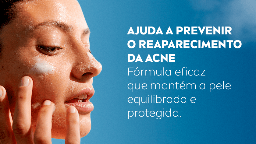 Mulher com lábios semiabertos, aplica o produto no rosto. O fundo é um céu azul.