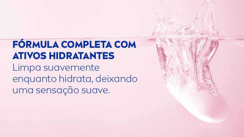 Fundo rosa-claro. No centro, há uma barra de sabonete sendo mergulhada na água, criando respingos e movimento no líquido.