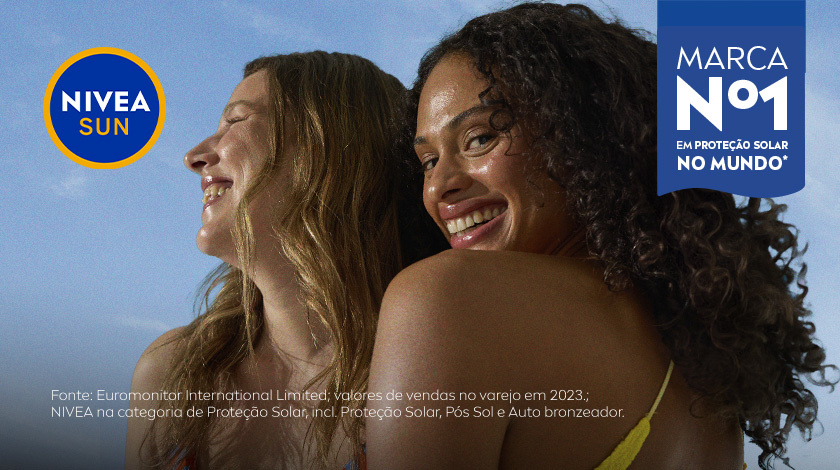 Duas mulheres sorrindo, uma de maiô listrado e outra de biquíni amarelo, com fundo azul.