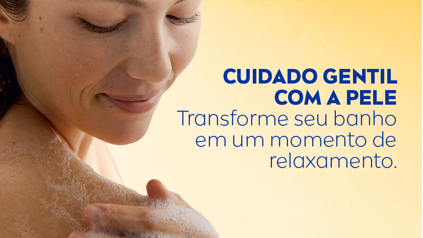 CUIDADO GENTIL COM A PELE Transforme seu banho em um momento de relaxamento. Mulher de pele clara e cabelos castanhos escuros molhados aparece sorrindo suavemente enquanto ensaboa o ombro com espuma. O fundo está em degradê em tons de amarelo. À direita, há o texto da NIVEA em azul escuro.
