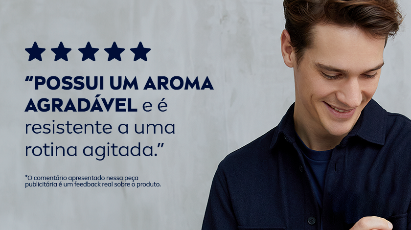 Homem jovem de pele clara e cabelo castanho escuro, sorrindo e olhando para baixo, vestido com camisa azul. Texto azul com cinco estrelas e mensagem sobre o aroma agradável e a resistência ao suor. Fundo azul claro com textura suave.
