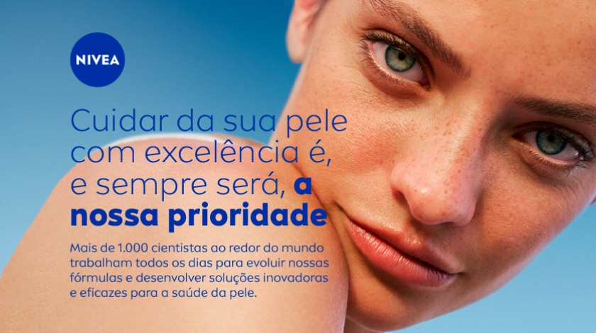 Close em um mulher de pele clara olhando para a câmera com fundo azul e mensagem sobre o compromisso da NIVEA com a qualidade dos cuidados com a pele.