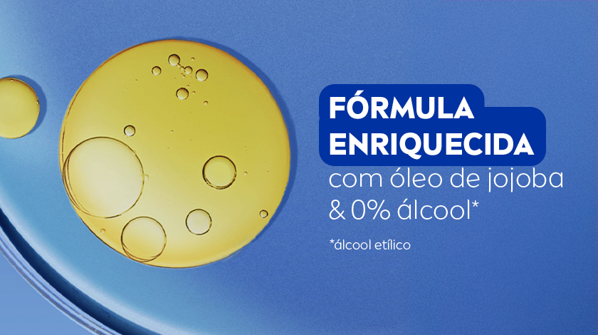 FÓRMULA ENRIQUECIDA com óleo de jojoba & 0% álcool* Imagem de cápsulas douradas de óleo em fundo azul escuro, representando a fórmula do produto.