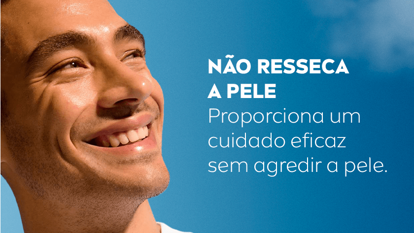 Homem sorri enquanto olha para cima, o fundo é um céu azul.