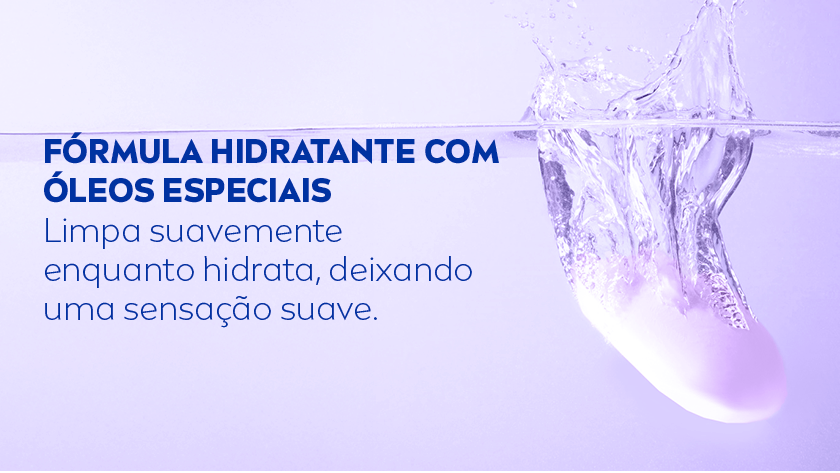 Fundo lilás. À direita, há uma barra de sabonete sendo mergulhada na água, criando respingos e movimento no líquido.