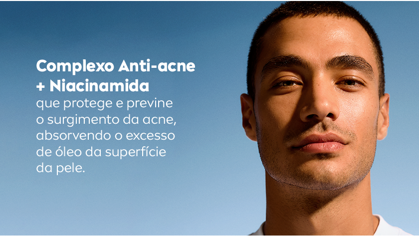 Um homem olha para frente, com expressão neutra. O fundo é um céu azul em degradê suave.