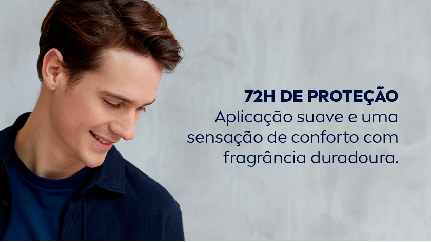 Um homem de camisa social escura sorri, olhando para baixo. O fundo é neutro.