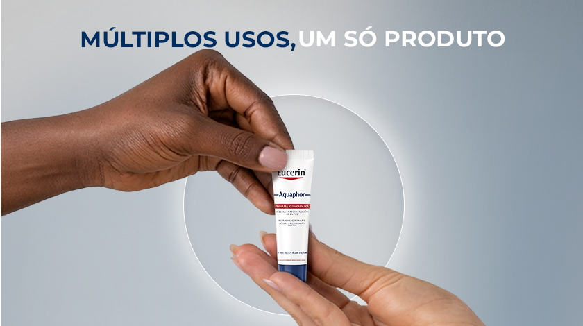 Uma mão de tom de pele retinto entrega uma pequena bisnaga de Eucerin Aquaphor para uma mão de tom de pele claro. No topo, a frase 
