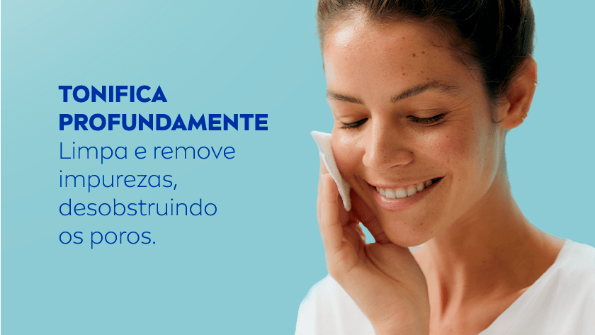 Mulher com expressão serena e sorridente limpa o rosto com um algodão, passando-o na bochecha. Ela está com os cabelos presos e veste uma blusa branca. O fundo é em tom azul claro.