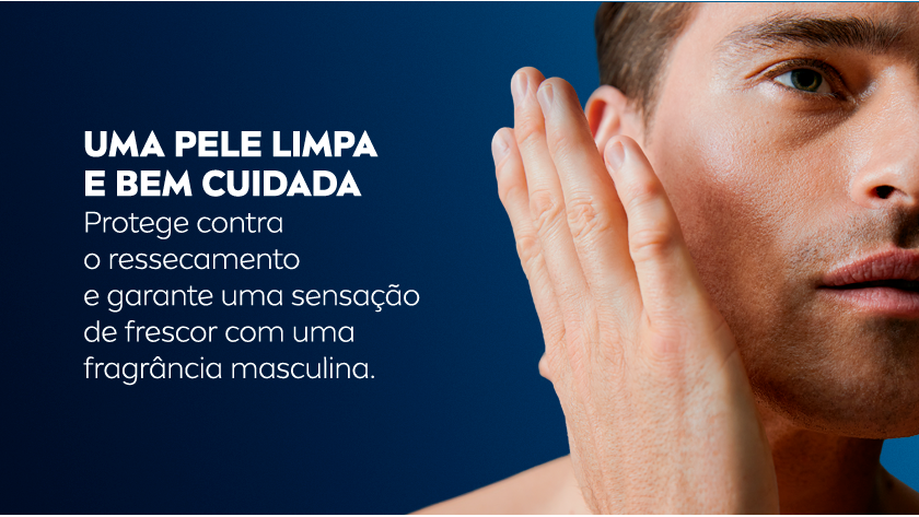 Homem branco de cabelos castanhos curtos coloca a mão aberta próxima do rosto. Fundo azul.