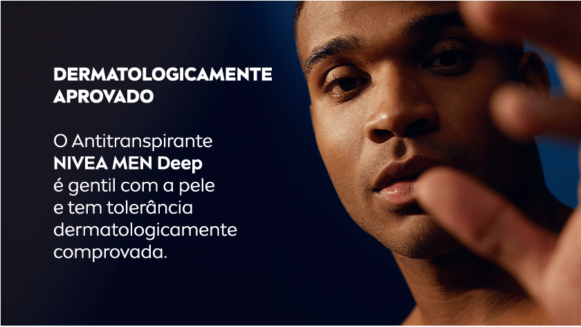 Homem negro em destaque olhando para a câmera com a mão parcialmente desfocada em primeiro plano. À esquerda, em fundo escuro, o texto é exibido.