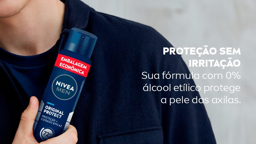 Homem vestindo camisa azul escura segura o desodorante NIVEA MEN Original Protect próximo ao peito. O frasco é azul escuro com detalhes em branco e prata, destacando “72h”. Ao fundo, parede clara desfocada.