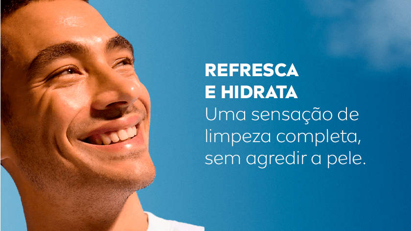 REFRESCA E HIDRATA Uma sensação de limpeza completa, sem agredir a pele. Homem sorrindo enquanto olha para cima. O fundo é um céu azul.