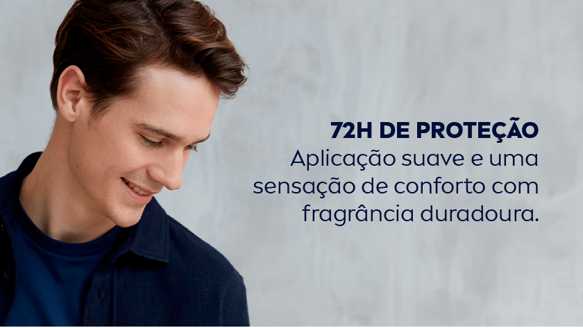 Imagem de um homem sorrindo, com blusa azul escura, olhando para baixo. O fundo é neutro.
