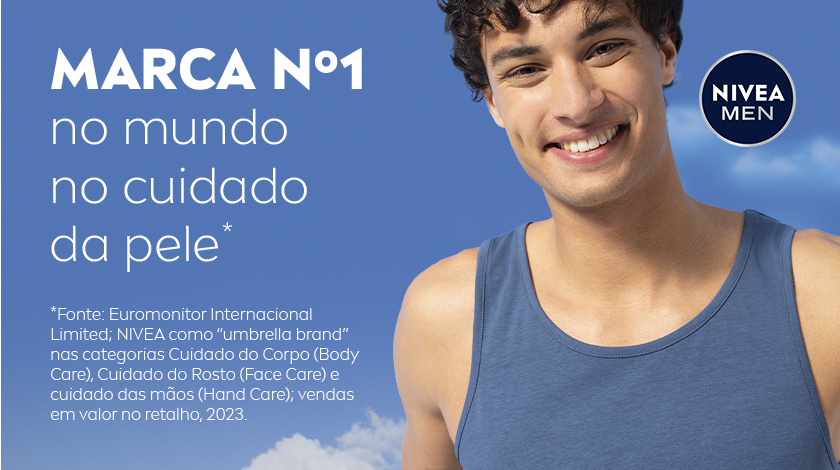 Homem sorridente com regata azul em frente ao céu azul com nuvens.