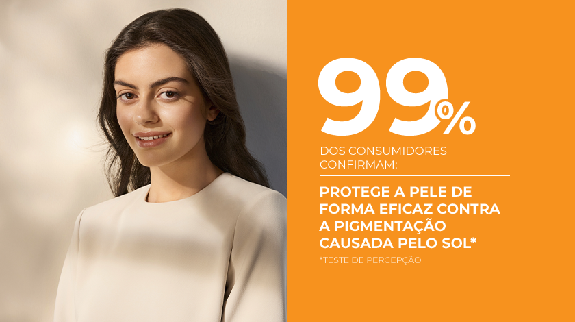 Uma mulher de pele saudável e radiante sorri ao lado de um fundo laranja.