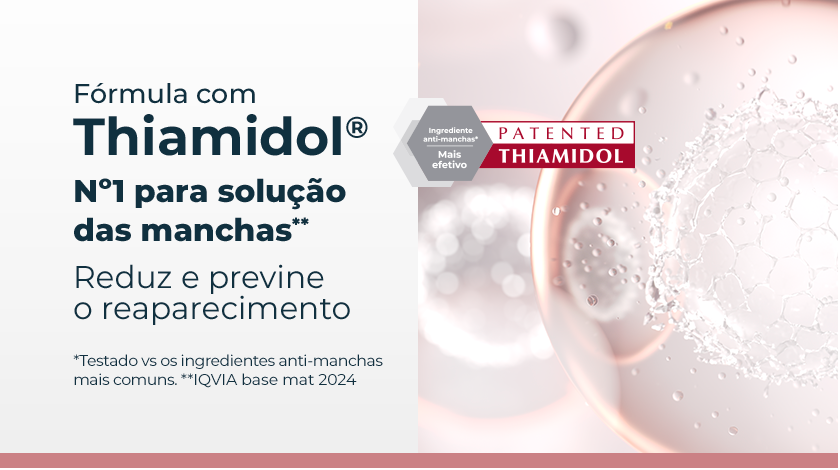 Banner publicitário com fundo claro, mostrando esferas translúcidas em tons de rosa e branco, com textura interna que lembra moléculas ou células, remetendo à ideia de ciência e eficácia. À esquerda, um selo hexagonal cinza e vermelho destaca a patente do ingrediente ativo Thiamidol.