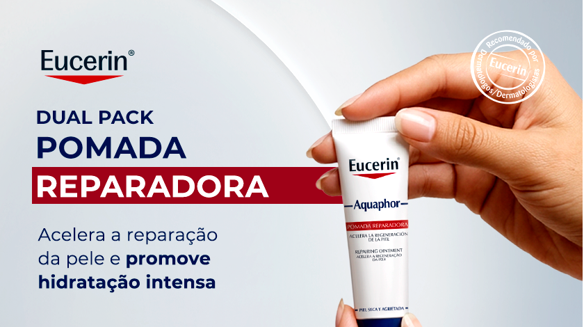 Uma mão segura uma bisnaga pequena de Eucerin Aquaphor contra um fundo clean. À esquerda, os textos 