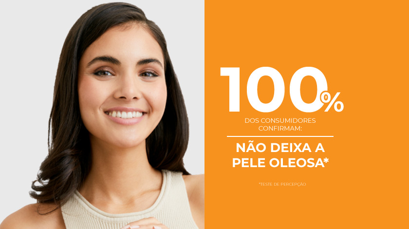 Uma mulher de pele saudável e radiante sorri ao lado de um fundo laranja.