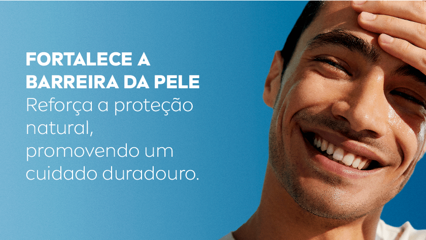 Um homem sorri com a mão na testa. O fundo é um céu azul.