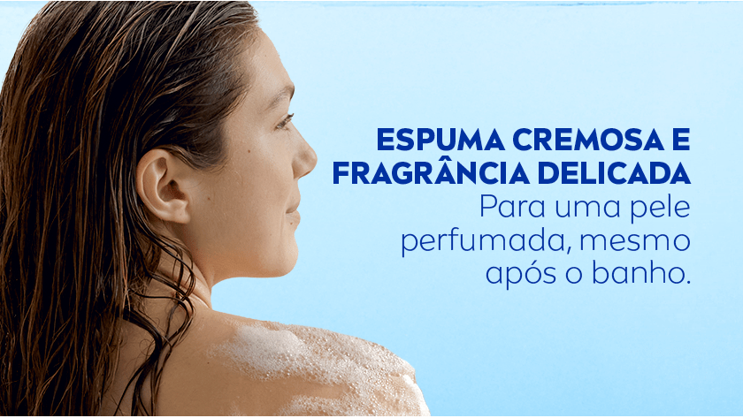 Mulher tomando banho com espuma no ombro, o fundo é azul.