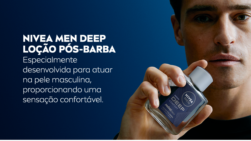 Homem branco de cabelos castanhos curtos segura a loção NIVEA MEN DEEP COMFORT próximo ao rosto. Fundo azul.