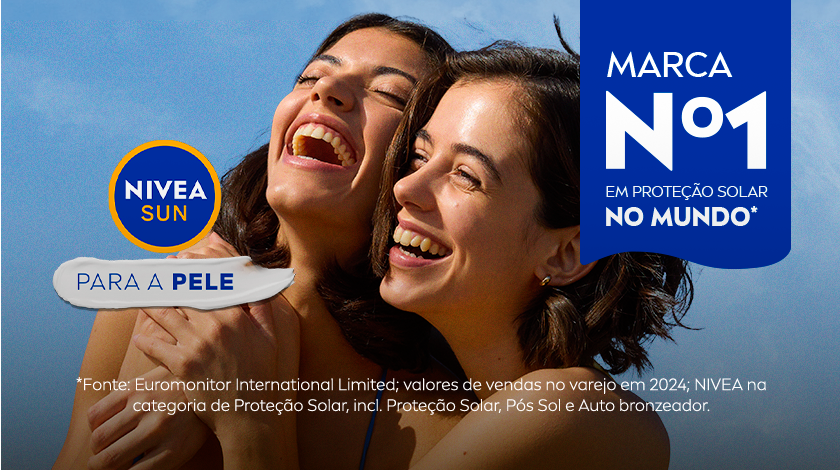 Duas mulheres sorrindo juntas na praia, cabelos ao vento, uma delas abraçando a outra. Logo NIVEA Sun acompanhado do selo 