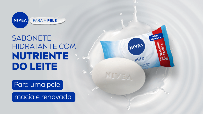 Barra de sabonete branca da marca NIVEA envolta por gotas de leite, com embalagem azul e branca ao lado, sobre um fundo com ondas suaves. Destaca benefícios hidratantes do leite para a pele.