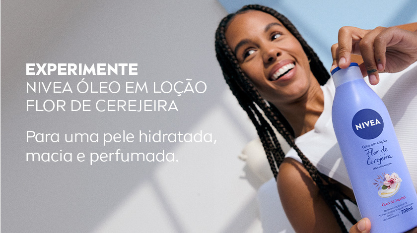 Imagem de mulher sorrindo aplicando o NIVEA Flor de Cerejeira, com fundo claro.