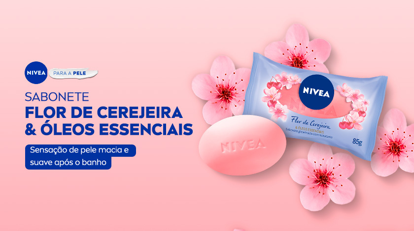 Imagem de sabonete NIVEA Flor de Cerejeira & Óleos Essenciais em barra rosa, ao lado da embalagem azul com flores de cerejeira em fundo rosa claro.