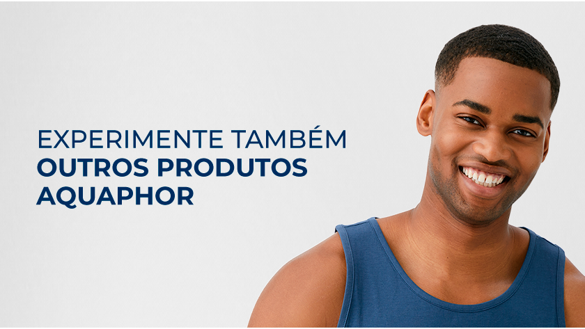 Imagem com fundo neutro. Ao lado direito, um homem sorri, ele usa uma regata azul