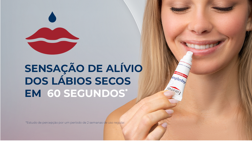 Uma mulher loira sorrindo enquanto aplica o reparador labial nos lábios. À esquerda, um ícone de lábios com uma gota e o texto 
