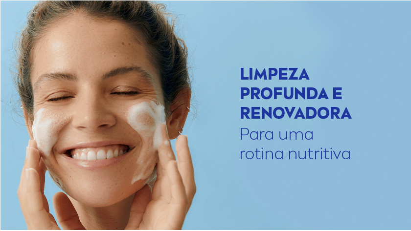 Fundo azul claro. À esquerda, uma mulher de pele clara e cabelos castanhos presos aparece sorrindo com os olhos fechados, aplicando espuma de limpeza no rosto com as mãos.